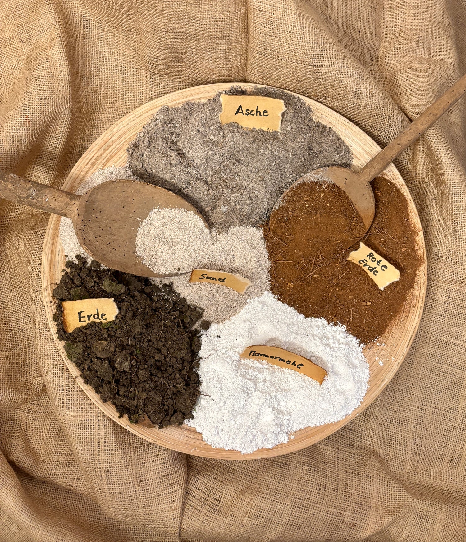 Materialien für ein abstraktes Gemälde mit roter Erde aus Kroatien, Asche und Goldspray auf Leinwand